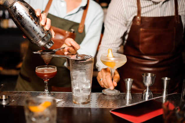 Bartenders preparing a cocktail from a manufacture of bitter drinks